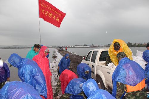 8月1日,武警呼倫貝爾森林支隊(duì)官兵在額爾古納河河岸冒雨加固堤壩。新華社發(fā)(杜俊奇 攝)