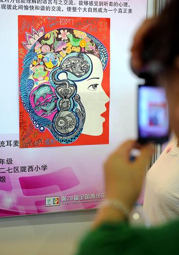 8月3日,觀眾在參觀獲得全國(guó)一等獎(jiǎng)的142幅優(yōu)秀少兒科學(xué)幻想繪畫作品之一的《萬物交流耳麥》。新華社記者孫參攝