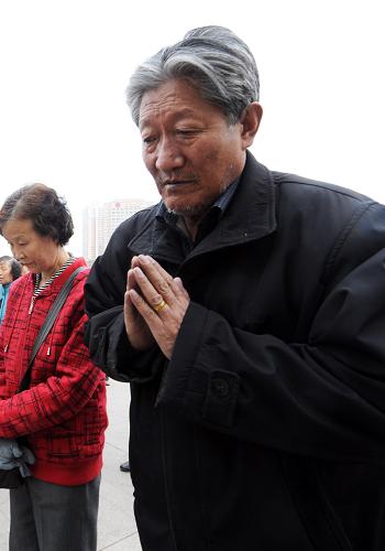 4月14日,74歲的藏族老人公卻拉加(右一)在西寧市中心廣場為玉樹災(zāi)區(qū)默哀祈福。新華社記者 侯德強(qiáng) 攝