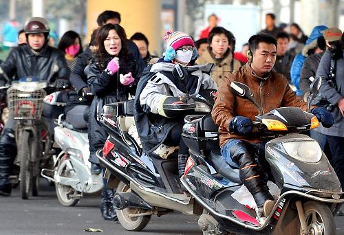 幾位鄭州市民騎電動車趕路(2009年12月2日攝)。 日前,國家四部委聯(lián)合下發(fā)《關(guān)于加強電動車管理》通知,要求各省依照現(xiàn)有規(guī)定限期淘汰時速達(dá)30公里以上的在用“超標(biāo)”電動車,并按照現(xiàn)有標(biāo)準(zhǔn)整改電動自行車產(chǎn)業(yè)。 消息一出,讓原本就處在機動車與非機動車“夾縫”中尷尬生存的電動自行車再次成了眾人矚目的焦點。據(jù)鄭州市交管部門統(tǒng)計,目前鄭州市的電動自行車已超過50萬輛,其中時速超過30公里的“電摩”占絕大多數(shù)。電動車車速的“超標(biāo)”,加之駕車人交通意識淡薄,已成為城區(qū)交通事故主要誘因。但由于“打擊面”太大,交警部門對電動車超速行駛這種交通違法行為,也很難逐個治理。 另有資料顯示,目前全國電動車的擁有量已超過1億輛,如果按照新國標(biāo)執(zhí)行,不僅大部分電動車將在新規(guī)則下成為廢品或“黑戶”,更涉及數(shù)以千計的企業(yè)生存及行業(yè)的發(fā)展。新華社記者 王頌 攝