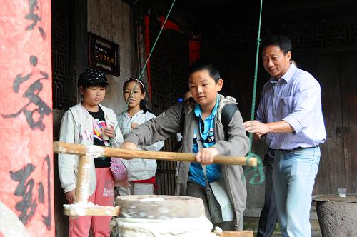 10月7日,幾名孩子在寧??h前童古鎮(zhèn)體驗(yàn)?zāi)ザ垢.?dāng)?shù)赝ㄟ^發(fā)展特色旅游帶動(dòng)了農(nóng)民致富。新華社記者 黃深鋼 攝