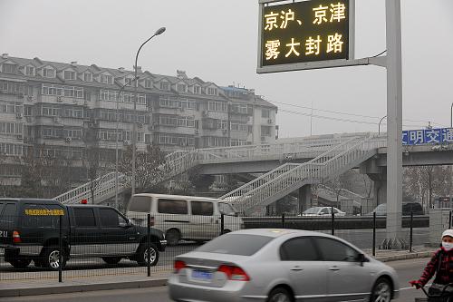 12月5日,大霧中的石景山蓮石東路警示牌顯示京滬、京津霧大封路的字樣。新華社記者 何俊昌 攝