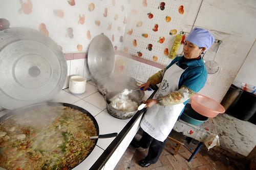 12月5日,朱套小學(xué)定點托餐農(nóng)戶正在準(zhǔn)備孩子們的免費午餐。新華社記者 彭昭之 攝