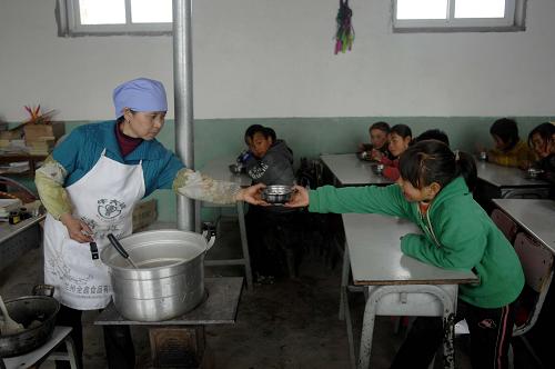 12月5日,朱套小學(xué)的一位學(xué)生從定點托餐農(nóng)戶手中接過第二碗飯。新華社記者 彭昭之 攝