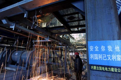 12月8日,工人在內(nèi)蒙古蒙能公司錫林浩特市新區(qū)熱源點(diǎn)建設(shè)現(xiàn)場焊接設(shè)備。新華社記者 張領(lǐng) 攝
