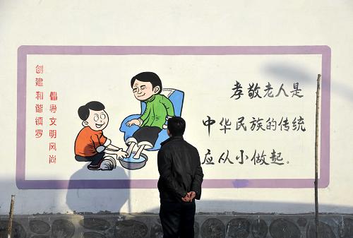寧夏中衛(wèi)市沙坡頭區(qū)鎮(zhèn)羅鎮(zhèn)河溝村一名村民在觀看村里的文化墻(1月31日攝)。近日,記者在寧夏中部地區(qū)走訪時發(fā)現(xiàn),遍布農(nóng)村的墻體標語中,宣講式的口號少了,圖文并茂、貼近百姓生活、表現(xiàn)方式獨特的“文化墻”呈現(xiàn)在群眾的視野中。這些“文化墻”采用圖畫、順口溜、詩歌等村民喜聞樂見的形式,宣傳環(huán)保知識、家庭美德、法律知識、衛(wèi)生常識等,展示了新農(nóng)村的良好風貌。新華社記者 彭昭之 攝