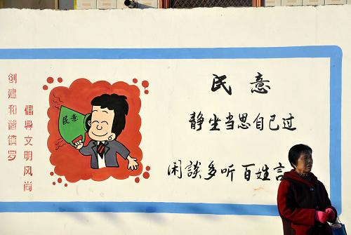 寧夏中衛(wèi)市沙坡頭區(qū)鎮(zhèn)羅鎮(zhèn)河溝村一名村民從村里一文化墻前走過(1月31日攝)。新華社記者 彭昭之 攝