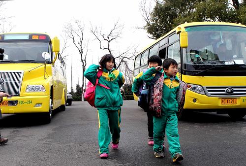 2月7日,校車抵達(dá)新海學(xué)校,學(xué)生們下車走進(jìn)校門。 當(dāng)日是上海中小學(xué)校新學(xué)期開學(xué)日。上海市崇明縣的17輛新校車正式投入運(yùn)營(yíng),接送崇明北部、東南部六所學(xué)校的學(xué)生上下學(xué)。這批新校車包括9輛“大鼻子”校車和8輛平頭客車,每車可載學(xué)生35至50人,每座均配有安全帶,車前方裝有探頭,并安裝了車載GPS和DVR,由專門挑選的經(jīng)驗(yàn)豐富的司機(jī)駕駛。 這批新校車采用了創(chuàng)新性的管理模式:由縣政府出資統(tǒng)一購(gòu)買,由崇明巴士公交公司負(fù)責(zé)運(yùn)營(yíng),由縣教育局和學(xué)校配合管理(校方派出跟車員,負(fù)責(zé)清點(diǎn)人數(shù),聯(lián)系家長(zhǎng)),三方合力為中小學(xué)生的上下學(xué)“保駕護(hù)航”。新華社記者 劉穎 攝