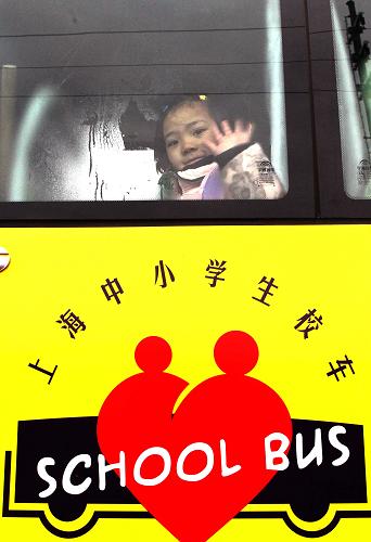 2月7日,新海學(xué)校四年級(jí)的嚴(yán)娟在新校車上揮手。新華社記者 劉穎 攝