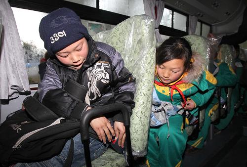 2月7日,一上校車,施佳佳(右)就督促同學(xué)系好安全帶。新華社記者 劉穎 攝