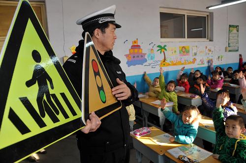 2月7日,河北邢臺(tái)育才小學(xué)學(xué)生在課堂上聽交警講交通安全知識(shí)并舉手回答問題。新華社發(fā)(黃濤 攝)