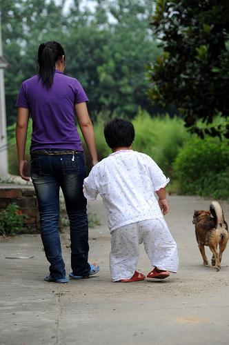 女兒戴路霞牽領(lǐng)腿腳不便又經(jīng)常犯眩暈癥的媽媽宋正鳳(右)出門(2011年9月7日攝)。18歲的戴路霞2011年走進(jìn)江蘇畜牧獸醫(yī)職業(yè)技術(shù)學(xué)院校門,正式成為一名大學(xué)生,養(yǎng)育了她18年的“微型媽媽”宋正鳳雖然沒能親自送養(yǎng)女到學(xué)校,但她說,這實現(xiàn)了自己作為一個幸福母親的愿望。隨著戴路霞的成長,宋正鳳,這名來自江蘇鎮(zhèn)江的“微型媽媽”將一個棄嬰培養(yǎng)成大學(xué)生的故事在網(wǎng)絡(luò)間流傳,感動了萬千網(wǎng)友。即便身高只有80厘米,縱然家中一貧如洗,這些都擋不住“微型媽媽”胸中那磅礴的母愛。新華社發(fā)