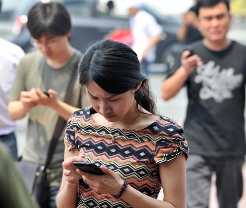 5月28日,在天津市區(qū),感到明顯震感的市民跑出戶外給親友發(fā)短信。新華社記者 岳月偉 攝