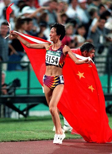 圖為1996年7月28日,王軍霞在獲第26屆亞特蘭大奧運會女子5000米金牌后,身披五星紅旗慶祝。新華社發(fā)