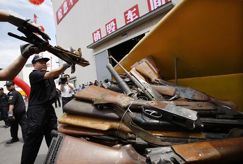 6月12日,特警把收繳的非法槍支搬上鏟車準(zhǔn)備集中銷毀。新華社發(fā)(萬(wàn)象 攝)