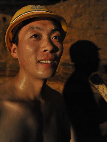 7月10日,掘進(jìn)工王飛在地下15米作業(yè)時汗流浹背。新華社記者 王昊飛 攝