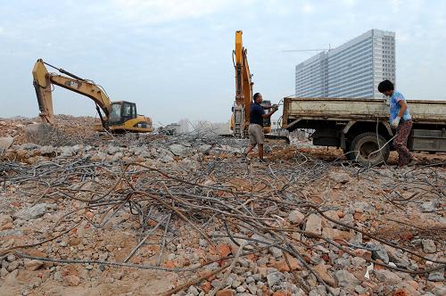 7月23日,人們?cè)卩嵵萋櫱f拆遷工地進(jìn)行清理。新華社記者 朱祥 攝
