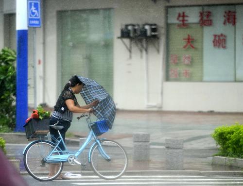 7月24日,在受臺風“韋森特”影響的廣東陽江街頭,市民冒雨頂風前行。當日凌晨,臺風“韋森特”在廣東臺山市赤溪鎮(zhèn)登陸。受其影響,廣東出現(xiàn)大風大暴雨。新華社記者 陳曄華 攝