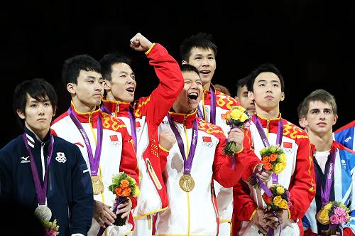 7月30日,中國隊(duì)選手馮喆、郭偉陽、陳一冰、張成龍和鄒凱(從左二至右二)在頒獎(jiǎng)儀式上慶祝。當(dāng)日,在2012年倫敦奧運(yùn)會體操男子團(tuán)體決賽中,中國隊(duì)以275.997的總分摘得金牌,成功衛(wèi)冕。日本隊(duì)和英國隊(duì)分別以271.952分的271.711分的總成績獲得銀牌和銅牌。新華社記者 王麗莉 攝