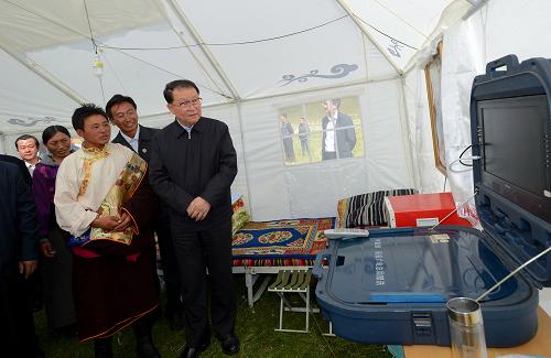 這是9月6日,李長(zhǎng)春在紅原縣下哈拉瑪村了解牧民“馬背電視機(jī)”使用效果。新華社記者 江宏景 攝