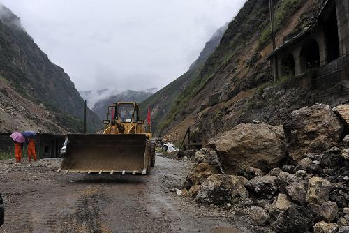 9月11日,挖掘機(jī)在一塌方處疏通道路。當(dāng)日凌晨,云南彝良地震災(zāi)區(qū)彝良縣境內(nèi)局部地區(qū)遭受單點(diǎn)性暴雨,截至7時(shí),縣城降雨量已達(dá)152毫米,通往云南彝良縣災(zāi)情最重的洛澤河鎮(zhèn)的交通生命線再次因暴雨引發(fā)的滑坡和塌方暫時(shí)中斷。記者冒險(xiǎn)翻過(guò)長(zhǎng)達(dá)70余米塌方地段,拍攝到救援人員全力疏通道路的畫(huà)面。由于多處塌方、滑坡造成路面上的土石量過(guò)大,道路搶通的時(shí)間暫時(shí)還不能確定。新華社記者 歐東衢 攝
