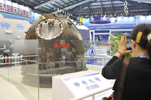 “嫦娥”“天宮”齊亮相 一位觀眾正在用手機(jī)拍攝珠海航展上展出的神九返回艙實(shí)物(11月14日攝)。 11月14日,在第九屆中國(guó)國(guó)際航空航天博覽會(huì)航天館內(nèi),神九返回艙實(shí)物、天宮神九對(duì)接組合體模型、嫦娥三號(hào)月球車模型等重量級(jí)展品亮相,吸引了眾多觀眾的目光。 新華社記者梁旭攝