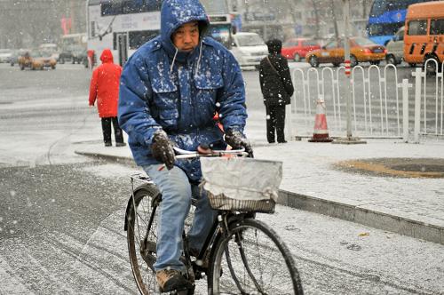 北京出現(xiàn)降雪天氣 12月12日,市民在雪中騎車前行。 當(dāng)日早晨,北京出現(xiàn)較大范圍降雪天氣。 新華社記者 孫瑞博 攝