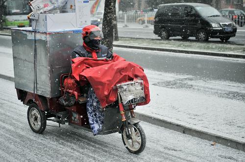 北京出現(xiàn)降雪天氣 12月12日,一名快遞員在雪中騎車前往目的地投遞物品。 當(dāng)日早晨,北京出現(xiàn)較大范圍降雪天氣。 新華社記者 孫瑞博 攝