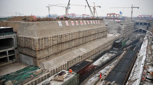 北京通州:建設(shè)中的現(xiàn)代化交通市政服務(wù)樞紐 這是北京通州區(qū)北環(huán)環(huán)隧立體交通市政服務(wù)樞紐的施工現(xiàn)場(1月15日攝)。 北環(huán)環(huán)隧立體交通市政服務(wù)樞紐位于北京通州北關(guān)大道與永順東街交會處,環(huán)隧深埋在北關(guān)北街、新華東路、永順南街、北關(guān)中路地下30多米處,主隧全長1.5公里,從上到下分為三層,依次為行車道、綜合管溝設(shè)備夾層、綜合管溝層。主隧道寬14.15米,布置成逆時針單向行駛的三條車道,設(shè)備夾層與綜合管廊將包含水、電、氣、熱、真空垃圾收集等多種管線。隧道設(shè)置了4對進(jìn)出口與地面道路相接,還設(shè)置了連接地下車庫的22處進(jìn)出口,可實(shí)現(xiàn)地塊與地塊間、地塊與市政道路間無縫銜接,緩解地面交通壓力。 北環(huán)環(huán)隧不僅融合了交通和市政管線,還要和周圍的地鐵、商業(yè)設(shè)施相互接駁,所有車輛都將在地下行駛,留出了充分的地面空間給市民享用。“一體化”的設(shè)計方案將環(huán)隧、商業(yè)設(shè)施、寫字樓、地鐵等多項工程統(tǒng)一協(xié)調(diào)施工,這樣既縮短了工期,又節(jié)約了大量工程成本。 新華社記者 李欣攝
