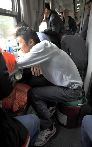 春運(yùn)路上這樣度過 2月2日,在廣州至成都的L570次列車上,一名旅客把裝滿東西的塑料桶當(dāng)?shù)首幼?2月2日7時許,L570次列車從廣州站發(fā)車,歷時近40小時,于3日晚10時許到達(dá)成都站。 新華社記者 陳曄華 攝