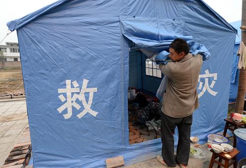 災(zāi)區(qū)見聞 4月23日,在蘆山縣一個受災(zāi)群眾安置點,一名受災(zāi)群眾在整理帳篷。 新華社記者 李鋼 攝