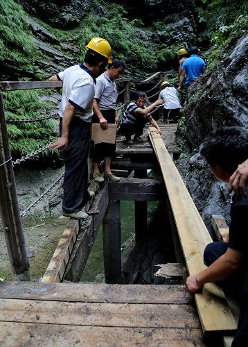 陜西金絲峽景區(qū)山體滑坡造成1人死亡18人受傷 7月21日,搶險(xiǎn)人員在金絲峽景區(qū)內(nèi)恢復(fù)道路。 當(dāng)日上午11時(shí)許,陜西商南縣金絲峽景區(qū)發(fā)生山體滑坡,造成1人死亡,18人受傷。據(jù)了解,發(fā)生滑坡的地點(diǎn)位于景區(qū)九龍?zhí)陡浇?,山石從近百米的高空墜下,飛散開(kāi)的石塊砸向眾多游人?;鹿苍斐?名男性游客死亡,18名游客受傷。其中,2人傷勢(shì)較重,一位女性腿骨和手臂骨折,另外一名男性頭皮擦傷肋骨骨折。目前,所有受傷人員都被送往金絲峽鎮(zhèn)醫(yī)院和商南縣人民醫(yī)院進(jìn)行救治。 新華社發(fā)