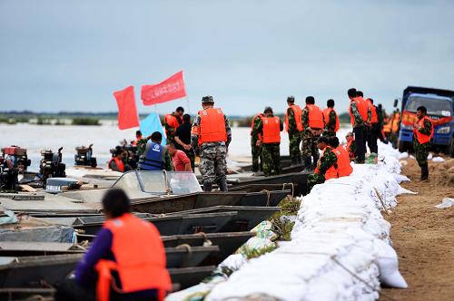 赫哲族漁民快艇隊(duì) 保護(hù)家園義務(wù)抗洪 8月19日,抗洪人員登上一艘赫哲族漁民的快艇,準(zhǔn)備奔赴另一個(gè)抗洪區(qū)域。 在黑龍江同江段八岔村抗洪一線上,有一支特殊的隊(duì)伍,他們就是當(dāng)?shù)睾照茏宕迕窠M成的義務(wù)快艇隊(duì)??焱ш?duì)的50名漁民絕大多數(shù)都是本村的赫哲族民兵和黨員,他們每天都睡在自己的小船上,餓了就隨便吃點(diǎn)??焱ш?duì)隨時(shí)待命,支援抗洪,保護(hù)家園。 同江市八岔鄉(xiāng)是中國(guó)人口最少的少數(shù)民族之一赫哲族的聚居地,他們雖已轉(zhuǎn)產(chǎn)種植糧食,打魚(yú)仍是他們主要收入來(lái)源之一。八岔鄉(xiāng)赫哲族村漁民們站在抗洪大堤上,指著堤壩下幾十步開(kāi)外的小村子,那里就是他們的家。他們的后面是已經(jīng)高出村子水平線五六米的洶涌洪水,村子和洪水之間,只是一道沙土堤壩。 同江市八岔鄉(xiāng)赫哲族村村支部書(shū)記尤明國(guó)說(shuō),義務(wù)快艇隊(duì)每天的任務(wù)就是運(yùn)送抗洪物資和抗洪人員,一天至少要跑四五趟。平常他們打魚(yú)的船只在此時(shí)發(fā)揮了關(guān)鍵作用。 據(jù)了解,同江市八岔赫哲族村全村153戶村民,除了義務(wù)快艇隊(duì)的50個(gè)人以外,其余人已經(jīng)全部轉(zhuǎn)移到安全地區(qū)。“萬(wàn)一將來(lái)這個(gè)大堤決堤,我們的船也可以在最短的時(shí)間內(nèi)救人,幫助運(yùn)送人員和物資。”一名快