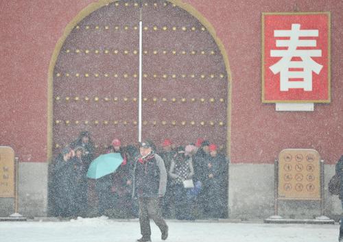 北京初雪 2月7日,游客在北京天壇公園門前避雪。 當(dāng)日,北京迎來今冬首場降雪。 新華社記者 李文 攝