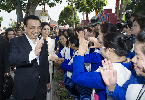10月13日,中國國務(wù)院總理李克強(qiáng)在泰國總理英拉陪同下,在清邁參觀“一村一產(chǎn)品”項(xiàng)目。這是李克強(qiáng)與當(dāng)?shù)厝罕娪H切交流。 新華社記者黃敬文 攝