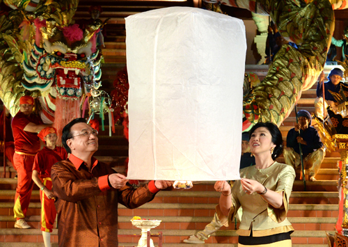 10月12日晚,中國國務(wù)院總理李克強(qiáng)在泰國清邁與泰國總理英拉身穿民族服裝,共同放飛“孔明燈”,為中泰友好祝福。 新華社記者 劉建生 攝