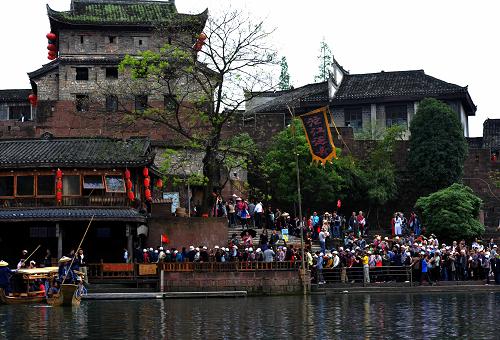 4月13日,鳳凰古城“大門票”包含的“沱江泛舟”碼頭,游客在排隊等候登船。新華社記者 趙眾志 攝