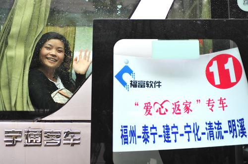 2月7日,乘坐“愛心返家”專車回家的外來務(wù)工者向送行的員工揮手道別。新華社記者 張國俊 攝
