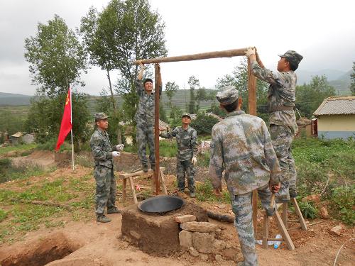 在岷縣申都鄉(xiāng)喬家溝,炊事班戰(zhàn)士為災區(qū)群眾搭建簡易廚房(7月24日攝)。 7月24日,蘭州軍區(qū)21集團軍某防化團一搜救分隊在岷縣申都鄉(xiāng)喬家溝搜救排查時發(fā)現(xiàn),由于地震,部分災區(qū)群眾家中的廚房倒塌,炊具被埋或已被砸壞,只能吃饅頭、方便面,喝礦泉水。該團官兵自發(fā)組織為災區(qū)群眾購買了幾口大鍋,炊事班戰(zhàn)士利用掌握的野戰(zhàn)炊事設備構(gòu)筑知識,為災區(qū)群眾架設起炊具,并手把手地教災區(qū)群眾如何利用鐵鍋、鐵盆等簡易容器進行野炊。炊煙升起時,喬家溝村村民高興地說:“我們又可以吃上熱飯了!”新華社發(fā)(高方錄 攝)