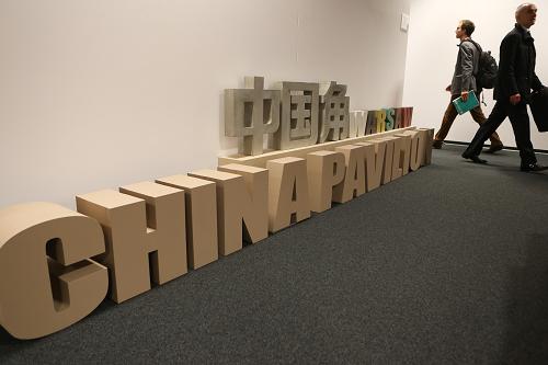 11月13日,在波蘭華沙,參會代表從“中國角”會場外經(jīng)過。新華社記者 張帆 攝
