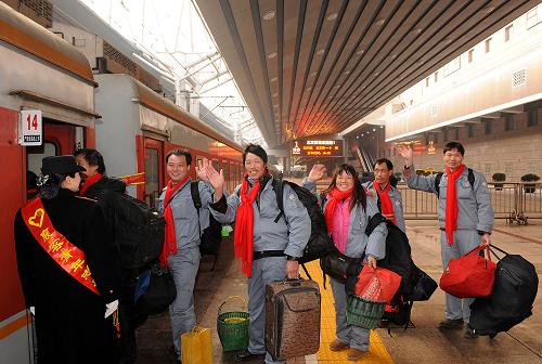 1月27日,幾名返鄉(xiāng)農(nóng)民工在北京西站排隊上車。新華社記者 何俊昌 攝