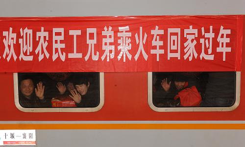 1月27日,幾名返鄉(xiāng)農(nóng)民工透過車窗向送行人群揮手道別。新華社記者 何俊昌 攝
