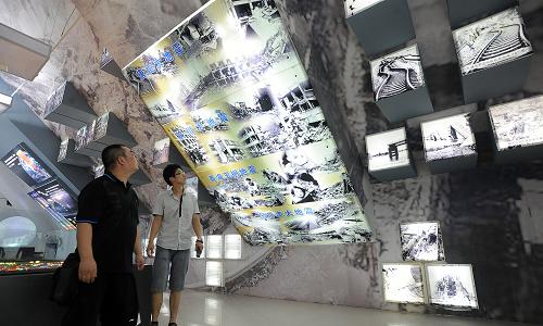 7月28日,市民在天津?yàn)I海防震減災(zāi)科普教育基地觀看地震災(zāi)害圖片。新華社發(fā)(蘭翔雁 攝)