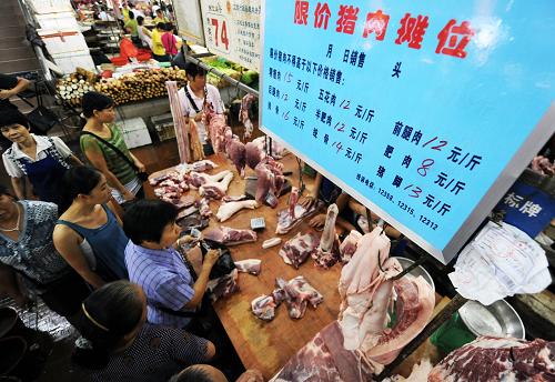 8月10日,市民在廣西防城港市金海市場(chǎng)“限價(jià)豬肉”攤點(diǎn)上選購(gòu)限價(jià)豬肉。新華社記者 李斌 攝