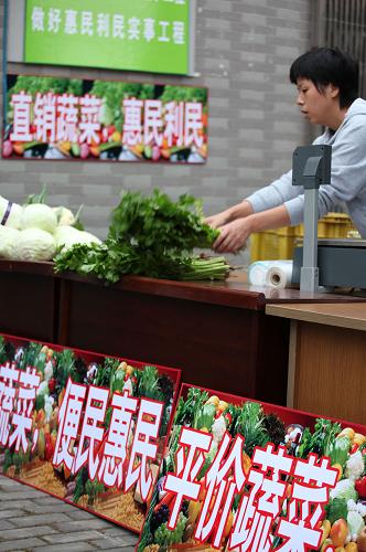 10月13日,在蘇州市城北街大觀名園社區(qū)的汽車蔬菜超市,工作人員正在擺放各類蔬菜。新華社發(fā)(李俊鋒 攝)