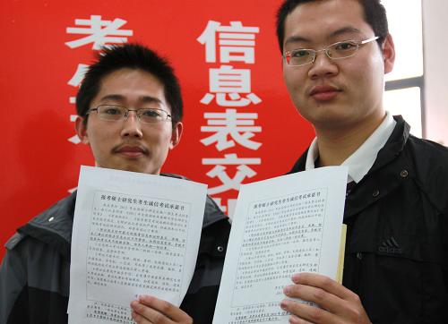 11月10日,在2012年全國碩士研究生統(tǒng)一入學(xué)考試江蘇大學(xué)報(bào)考點(diǎn),兩名報(bào)名考生展示現(xiàn)場簽訂的《考生誠信考試承諾書》。新華社發(fā)(楊雨 攝)