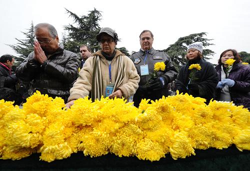 12月13日,參加集會的國際友人向南京大屠殺遇難者獻花。新華社記者 孫參 攝