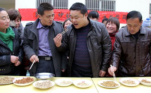 2月22日,在棗莊市市中區(qū)光明路街道東垎村,評委們在品嘗評比參賽村民炒的料豆。新華社發(fā)(吉喆 攝)