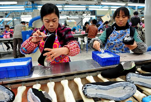 晉江遠通鞋業(yè)有限公司工人在生產(chǎn)布膠鞋(3月7日攝)。新華社記者 張國俊 攝