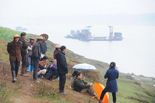 3月14日,在廣西桂平市南木鎮(zhèn)大黎村,村民在潯江岸邊等候親人的消息。廣西桂平市政府3月15日早晨舉行新聞發(fā)布會,通報桂平“3·11”水上交通事故搜尋和沉船打撈工作的最新情況。截至當日2時30分,確認死亡12人、失蹤8人。3月11日,廣西桂平市石咀鎮(zhèn)一客渡船在潯江江面與一貨船發(fā)生碰撞事故。事故造成一艘總噸位23噸、核定載客30人的客渡船翻沉。據(jù)記者15日凌晨從貴港市海事部門獲悉,經(jīng)查明,這起事故是由于大貨船未按規(guī)定航道航行、客渡船麻痹大意所致。新華社記者 黃孝邦 攝